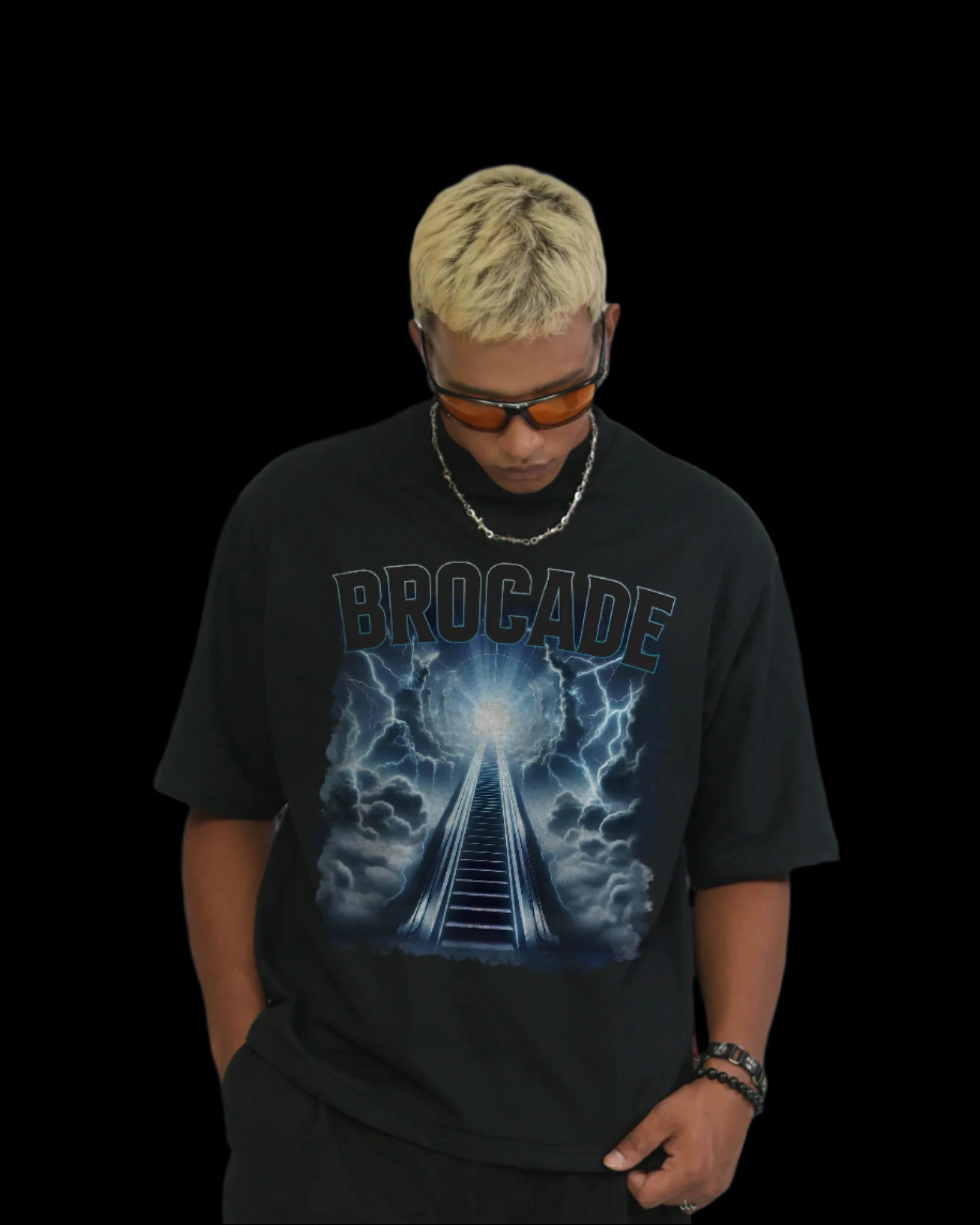 A person wearing sunglasses and a black t-shirt with a lightning design and the brand name 'BROCADE' printed across the chest.